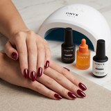 Manicura semipermanente con color rojo granate. En la imagen se ven los productos esenciales de onyx nails. 